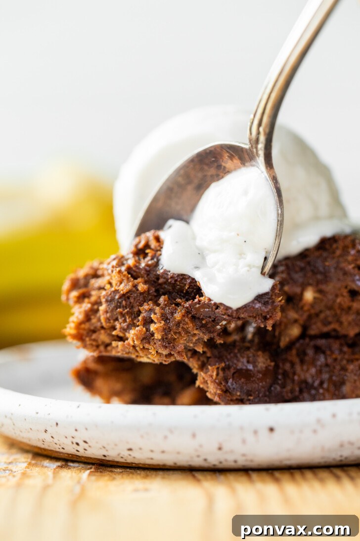 A slice of Vegan Flourless Banana Brownie with a bite taken out, showing the soft interior.