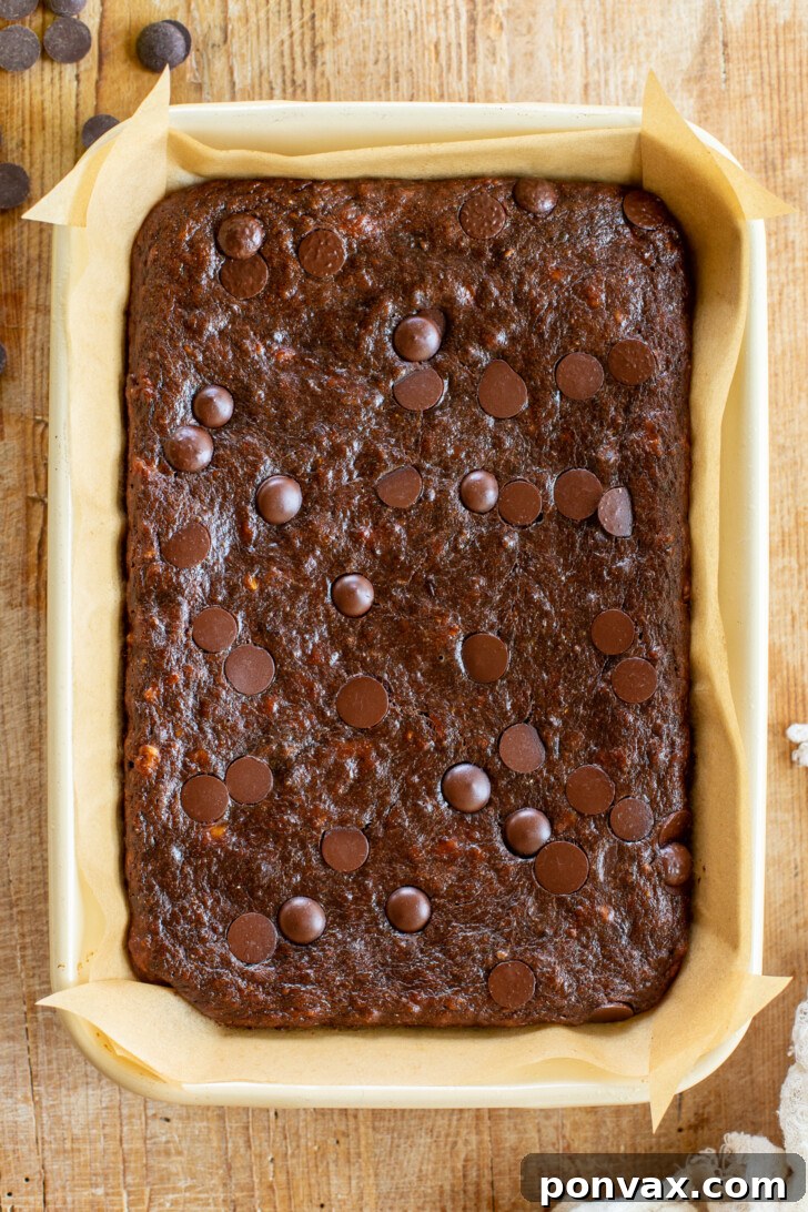Close-up of baked Vegan Flourless Banana Brownies, highlighting their fudgy texture and melted chocolate chips.