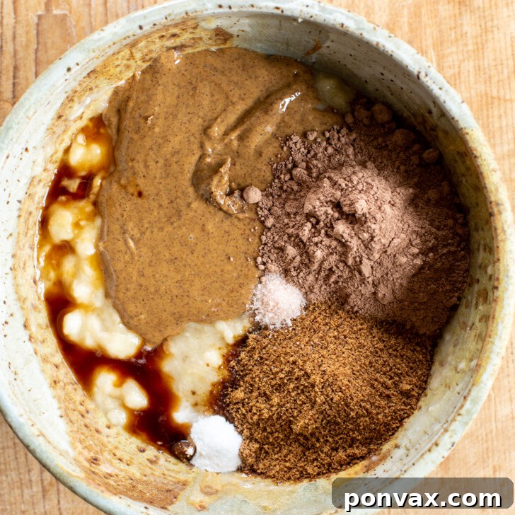 Smoothly mashed bananas in a mixing bowl, ready for other ingredients.