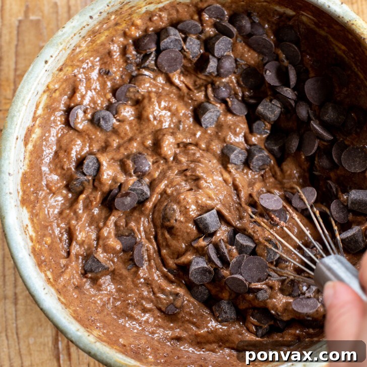 Whisking brownie batter until smooth and fully combined.
