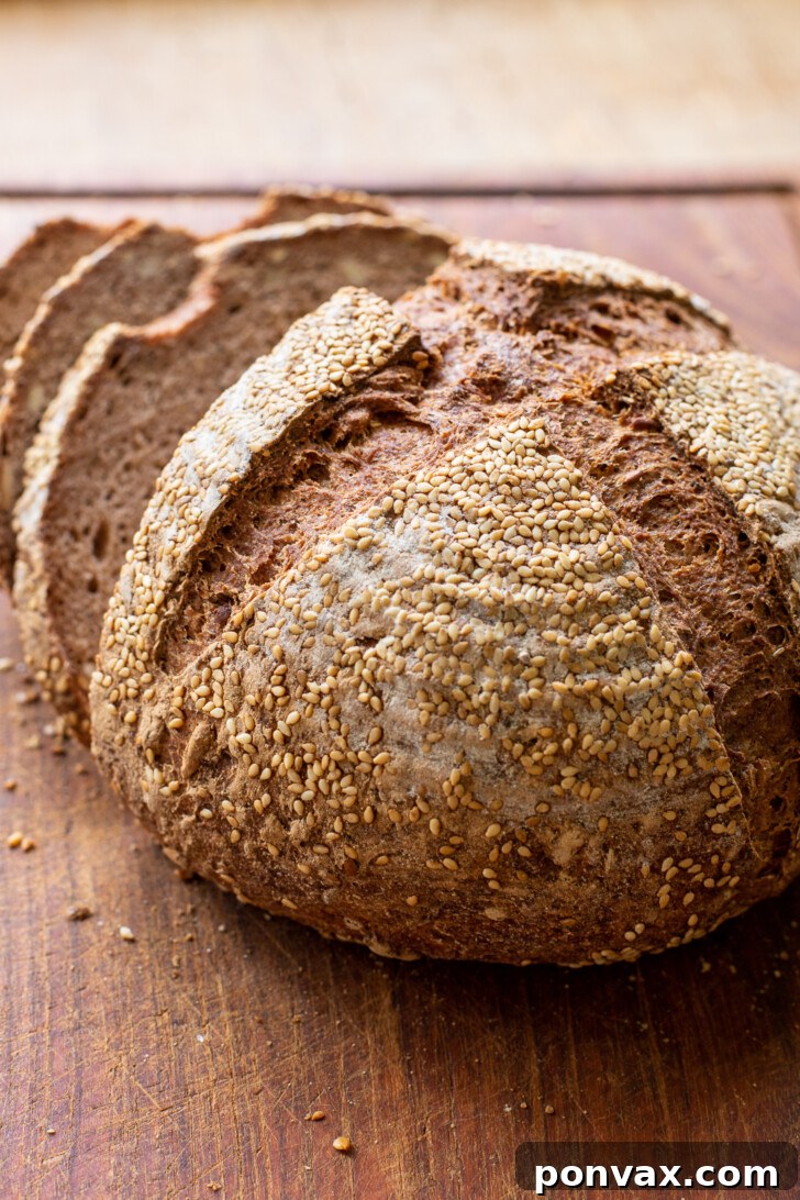 A perfectly sliced loaf of Gluten-Free Rye Bread, revealing its tender, caraway-speckled crumb.