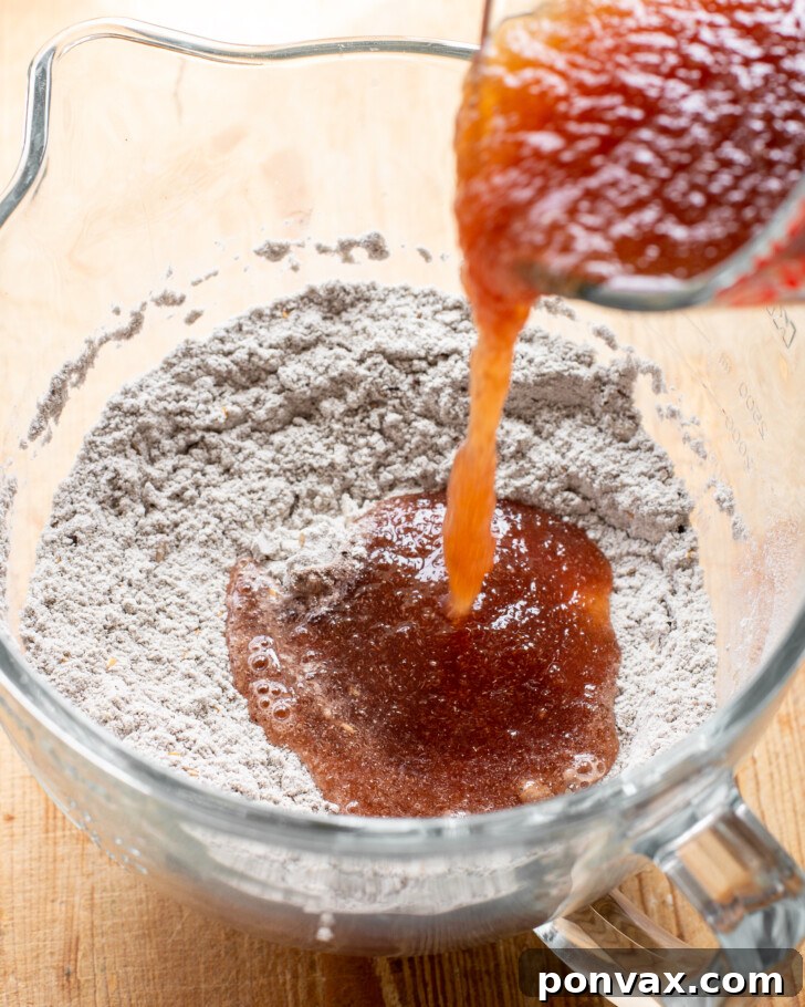 Step 4: Dough being shaped into a round loaf on a floured surface.