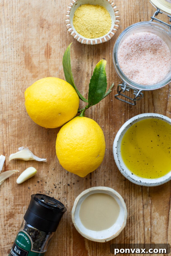 Close-up of a small bowl of creamy lemon vinaigrette with lemon slices and herbs, highlighting its fresh ingredients and inviting texture.