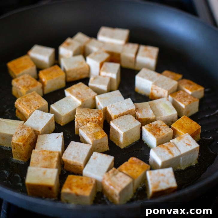 Flavor-Packed Sriracha Tofu Tacos 5 Step-by-step image 1: Tofu being cut into cubes.