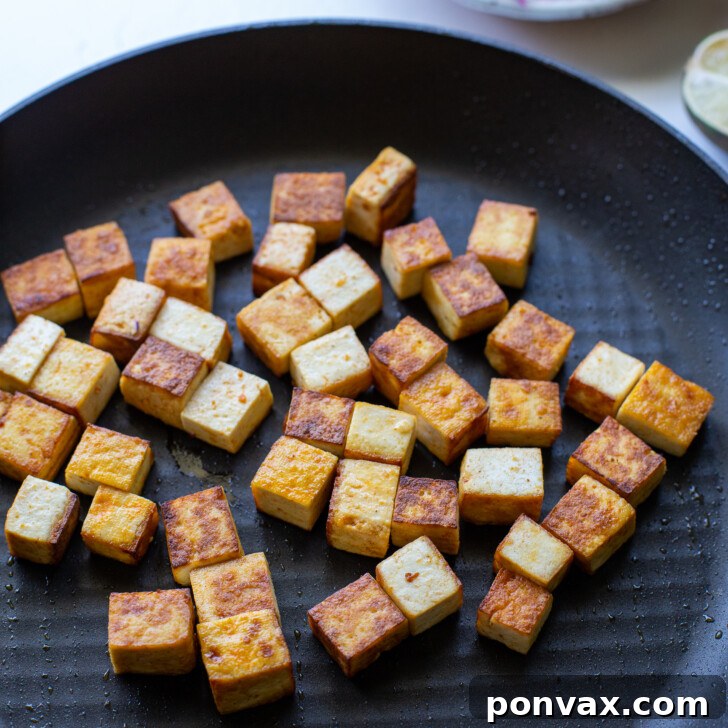 Flavor-Packed Sriracha Tofu Tacos 6 Step-by-step image 2: Tofu being sautéed in a pan.