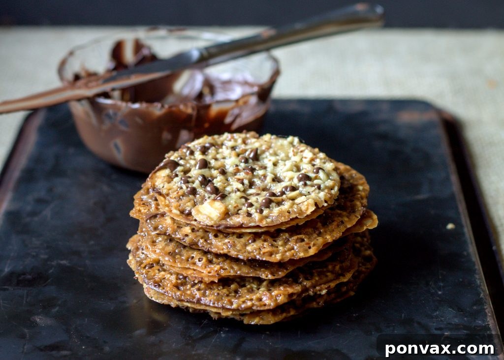 Irresistible Dark Chocolate Almond Lacey Cookies, featuring rich dark chocolate between two thin, crunchy almond cookies for a perfect sweet treat.