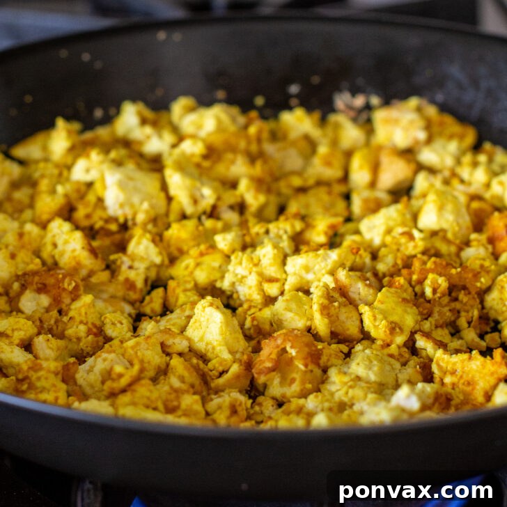 Step 4: Pushing tofu to one side and adding soy chorizo to the pan.