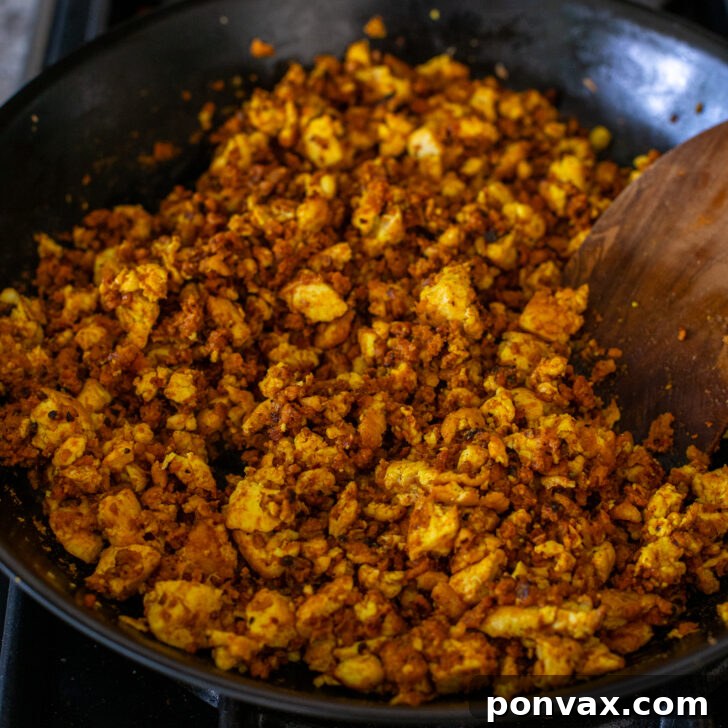 Step 6: Mixing the cooked tofu scramble and soy chorizo together in the pan.