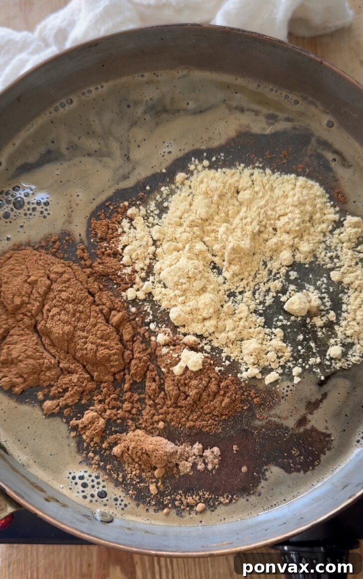 Handcrafted Gingerbread Elixir 5 Molasses being added to the saucepan with maple syrup, water, and coconut sugar for gingerbread syrup.