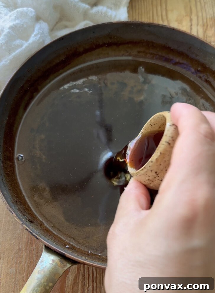Handcrafted Gingerbread Elixir 7 Homemade gingerbread syrup being poured into a glass jar for storage.