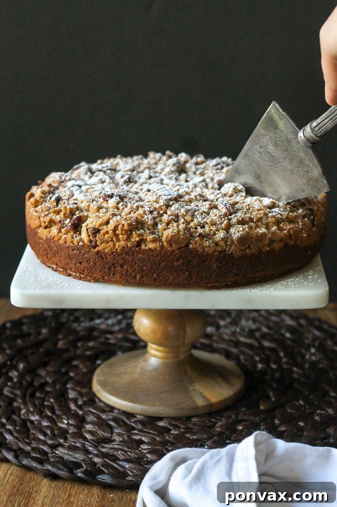A large, perfectly portioned slice of Pumpkin Crumb Cake served on a white plate, showcasing the distinct layers of moist cake and generous crumb.