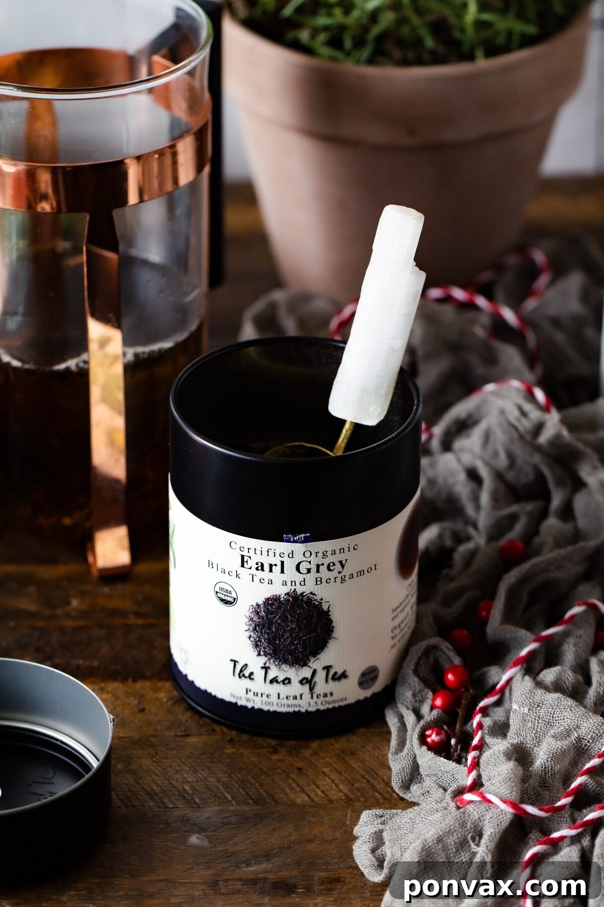 Close-up shot of a hand pouring frothed, creamy milk into a mug of dark Earl Grey tea, creating distinct layers and swirls, ready for enjoyment.