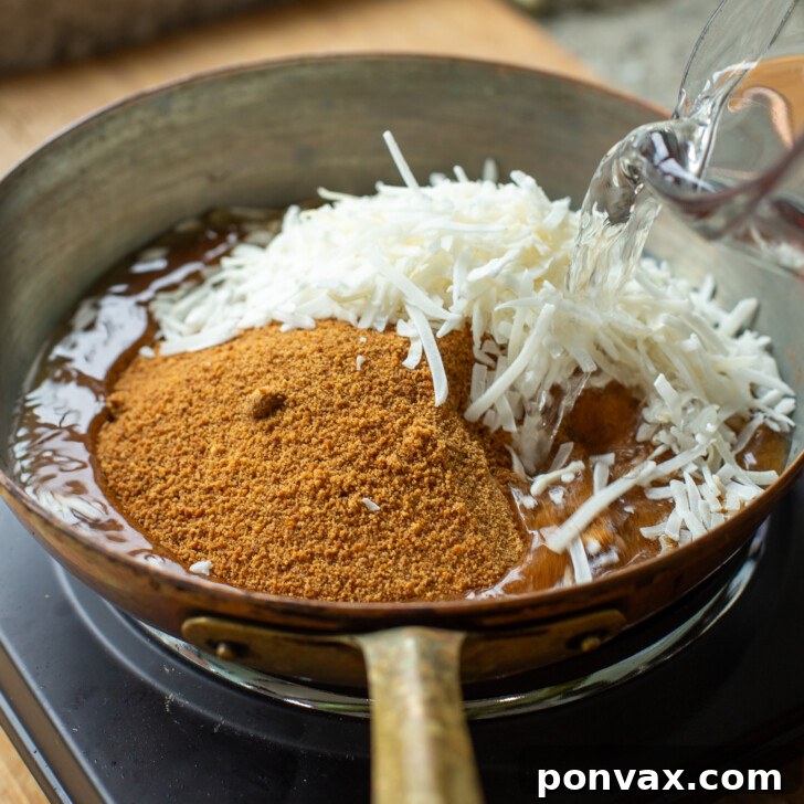 Tropical Coconut Elixir 5 A close-up of coconut flakes, water, and coconut sugar simmering in a saucepan.