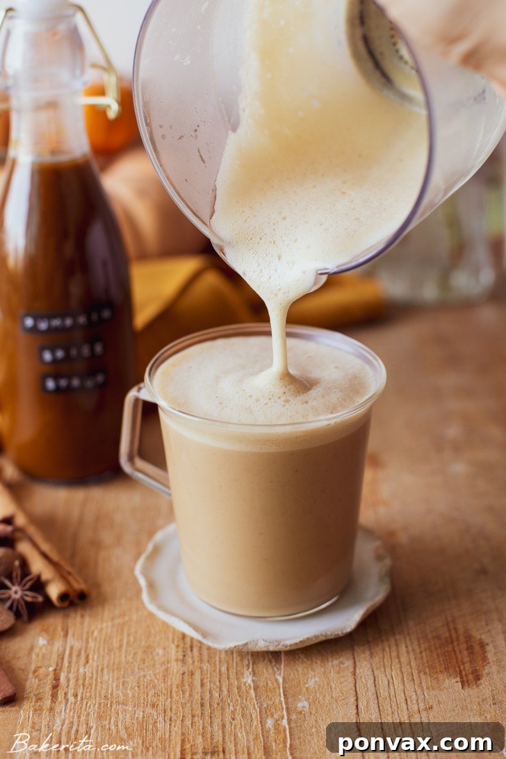 A close-up shot of a creamy pumpkin spice latte, showcasing its rich texture and a dusting of cinnamon on top. The background is softly blurred with warm autumn tones.