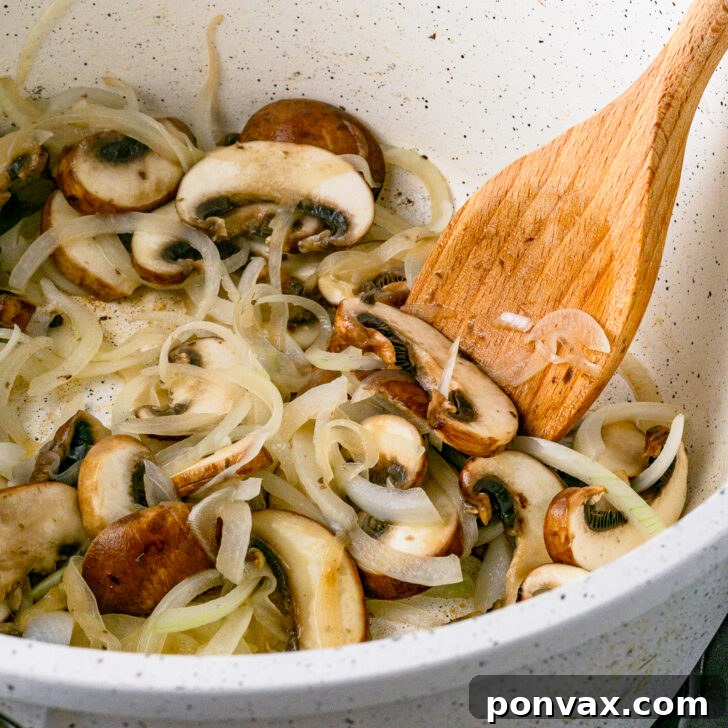 Wholesome One-Pot White Bean Mushroom Stew 5 Sliced onions and mushrooms sautéing in a pan as the first step for the stew.