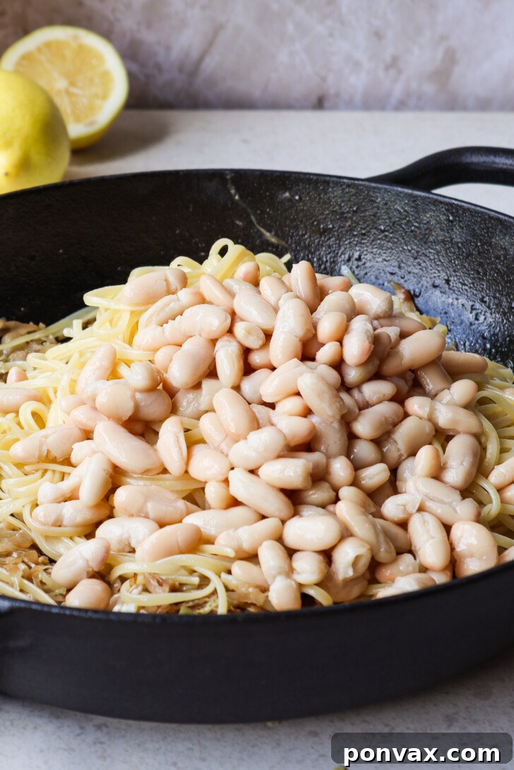 A close-up of the garnished Caramelized Cabbage Pasta, featuring fresh chives, vegan parmesan, and toasted walnuts for added texture.