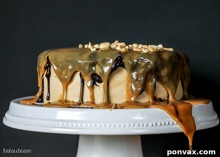 Snickers Overload Cake 2 The Ultimate Snickers Cake with six layers of rich chocolate, peanut caramel, and peanut butter frosting, draped in ganache and caramel.