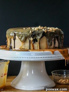 Snickers Overload Cake 3 The Ultimate Snickers Cake recipe image with peanut butter frosting and chocolate ganache.