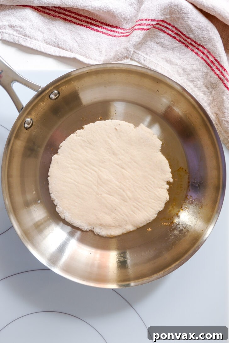 Step 7: Gently dimpling the rolled-out flatbread with fingertips before cooking.