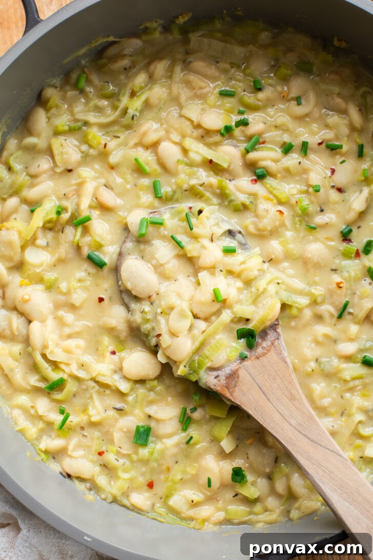 Silky Butter Beans with Zesty Leeks and Lemon 3 Close-up of Creamy Butter Beans with Leeks & Lemon, garnished with fresh herbs.