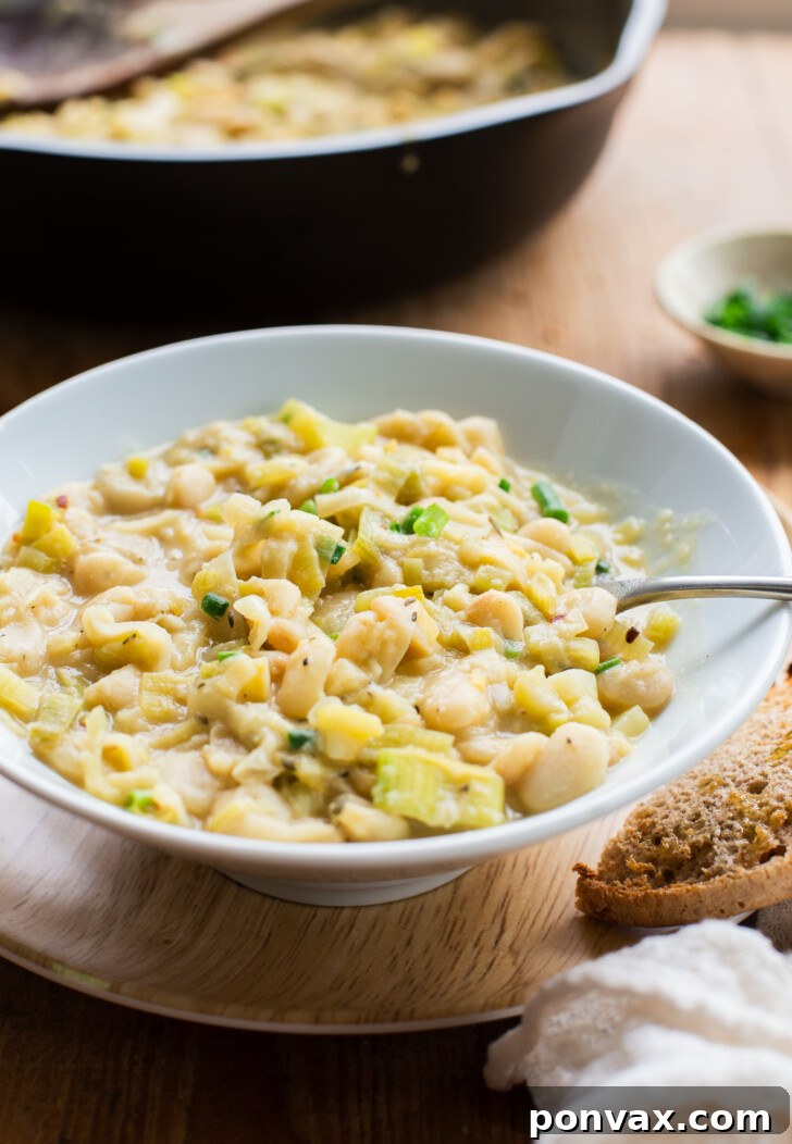 Silky Butter Beans with Zesty Leeks and Lemon 4 A bowl of Creamy Butter Beans with Leeks & Lemon with a spoon.