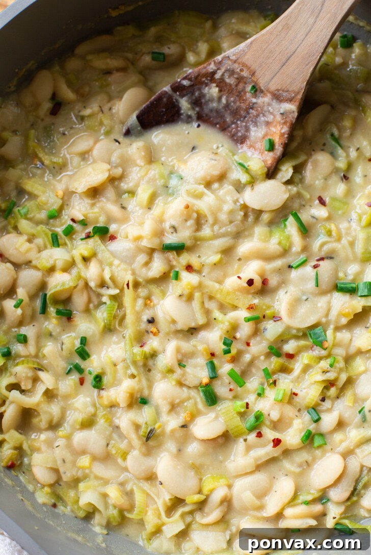 Silky Butter Beans with Zesty Leeks and Lemon 5 Close-up of the texture of Creamy Butter Beans with Leeks & Lemon, with a subtle golden hue.