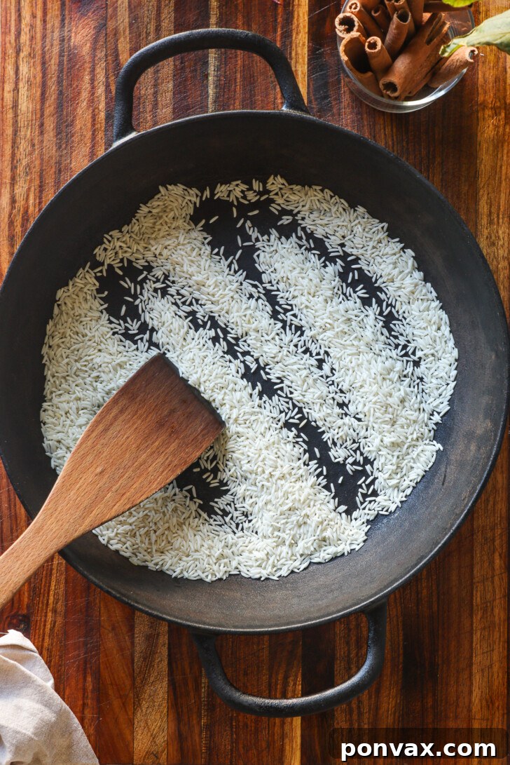 Uncooked white rice in a dry pan, gently toasting to release its aroma.