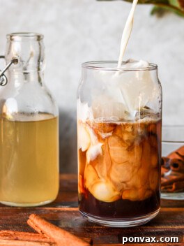Dairy-free oat milk being poured into iced coffee sweetened with homemade horchata syrup, inspired by Starbucks horchata shaken espresso.