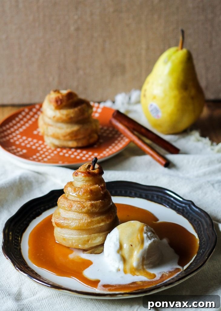 Exquisitely crafted Apple Cider Poached Pears in Cinnamon Sugar Puff Pastry, a delightful dessert easier to make than it appears, served with a homemade cider caramel sauce.