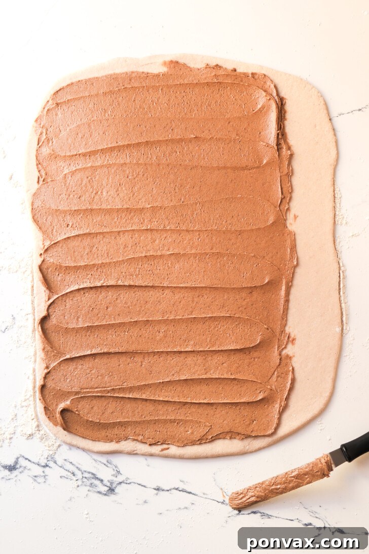 Irresistible Gluten-Free Sourdough Cinnamon Buns 12 Dough with cinnamon filling, ready to be rolled.