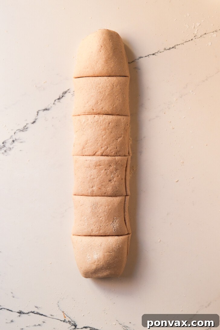 Irresistible Gluten-Free Sourdough Cinnamon Buns 15 Unbaked gluten-free sourdough cinnamon rolls in a baking pan.