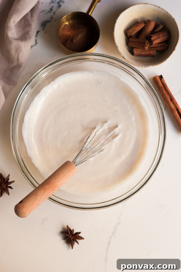 Irresistible Gluten-Free Sourdough Cinnamon Buns 17 Warm glaze being poured over freshly baked cinnamon rolls.
