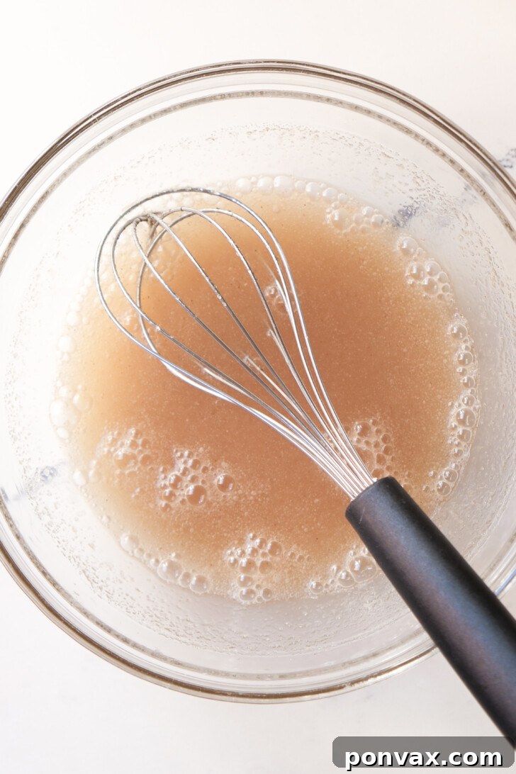 Irresistible Gluten-Free Sourdough Cinnamon Buns 6 Honey being stirred into the psyllium gel.