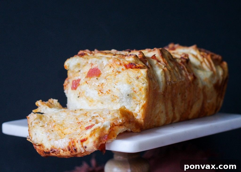 Side view of Pepperoni Pizza Pull Apart Bread, showing the distinct layers of dough, sauce, cheese, and pepperoni, with a rustic, homemade appeal.