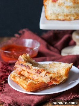 A slice of Pepperoni Pizza Pull Apart Bread, showing the rich filling and soft dough.