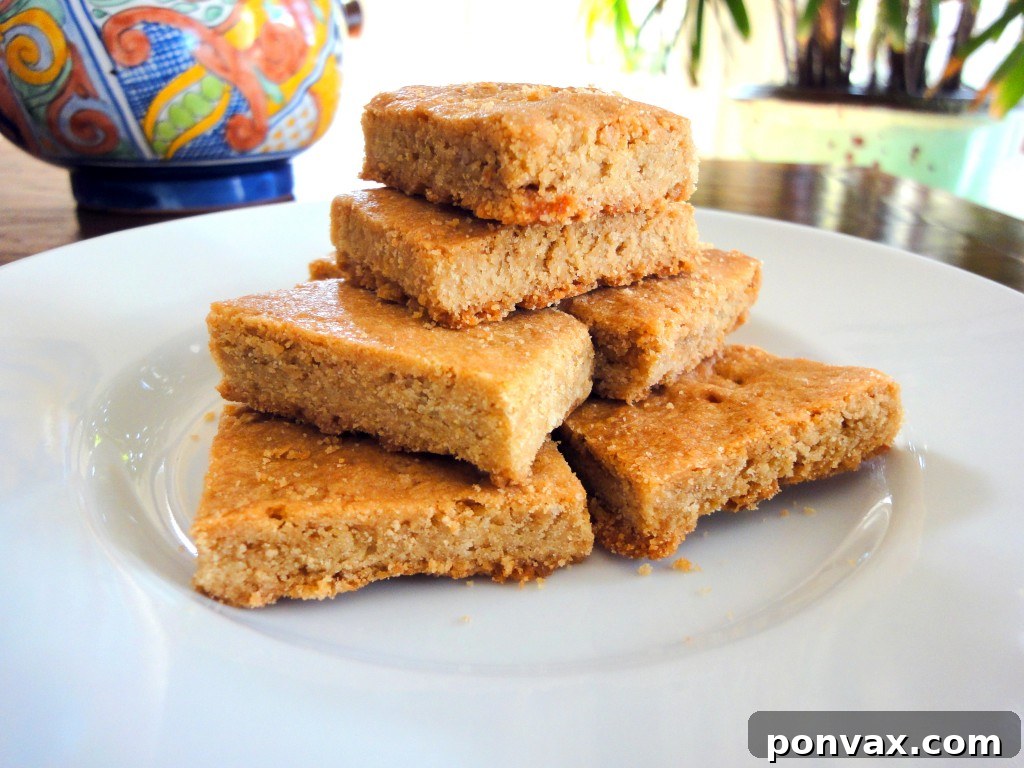 A large sheet of brown sugar shortbread, perfectly golden brown and ready to be cut, sits on a parchment-lined baking sheet.