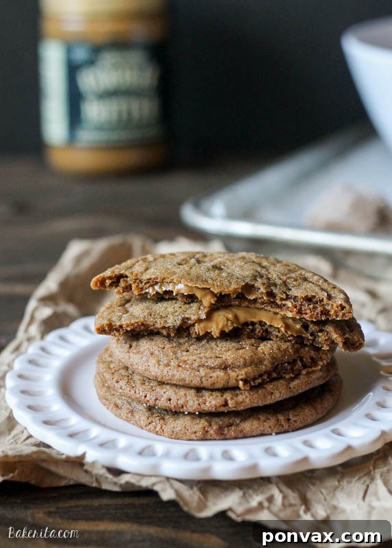 A close-up of a perfectly baked, sugar-rolled ginger cookie with a rich, soft texture, revealing a gooey cookie butter center, set against a warm, inviting background.