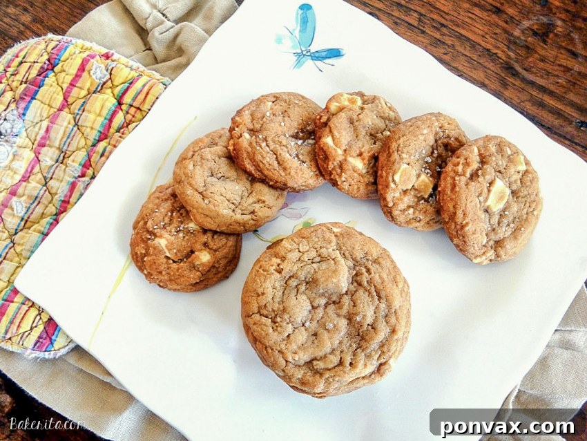 Moist, chewy Salted Caramel White Chocolate Cookies with visible caramel and white chocolate chunks, topped with fleur de sel.