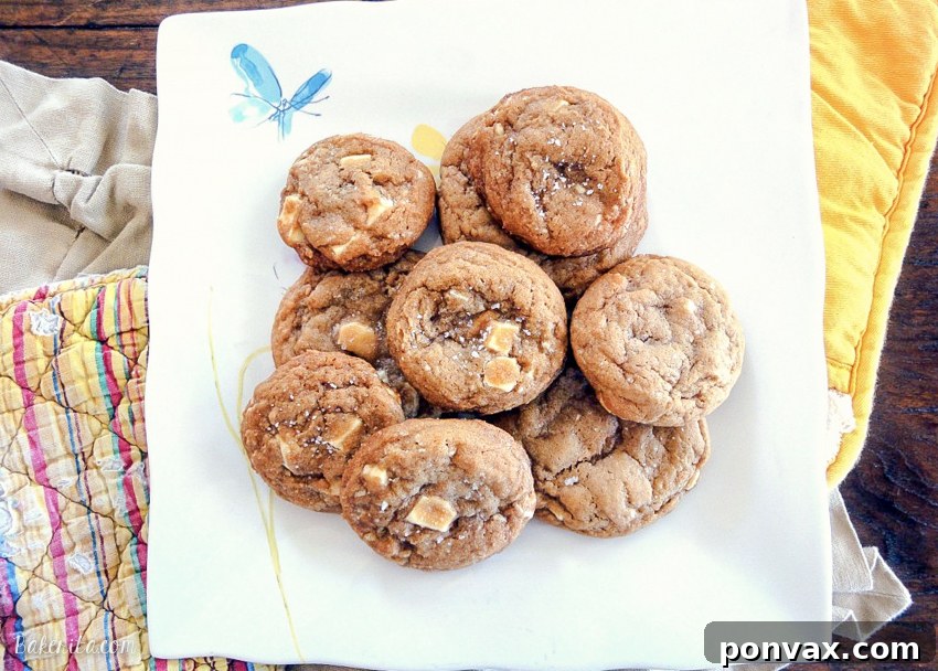 Close-up of baked Salted Caramel White Chocolate Cookies on a cooling rack, showcasing their golden edges and gooey centers.