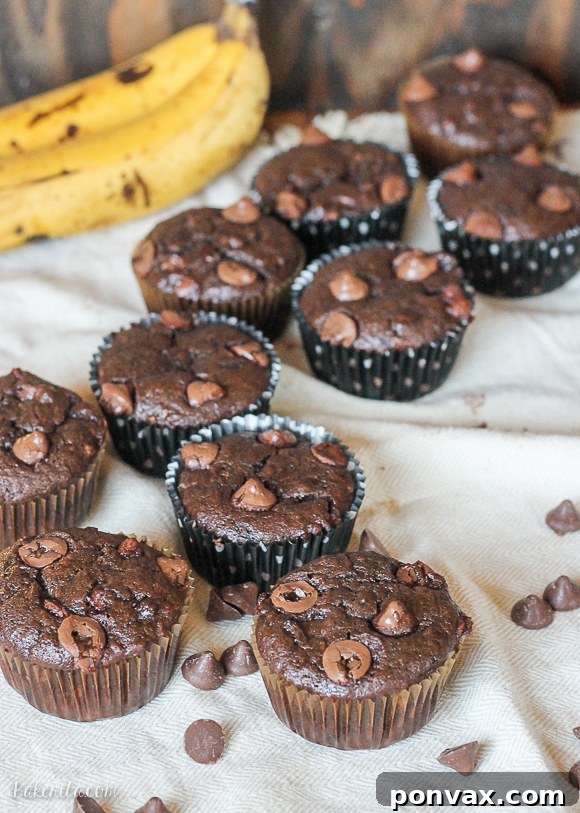 Decadent Chocolate Banana Muffins with Caramel Cores 4 A stack of freshly baked Caramel Filled Chocolate Banana Bread Muffins on a cooling rack.