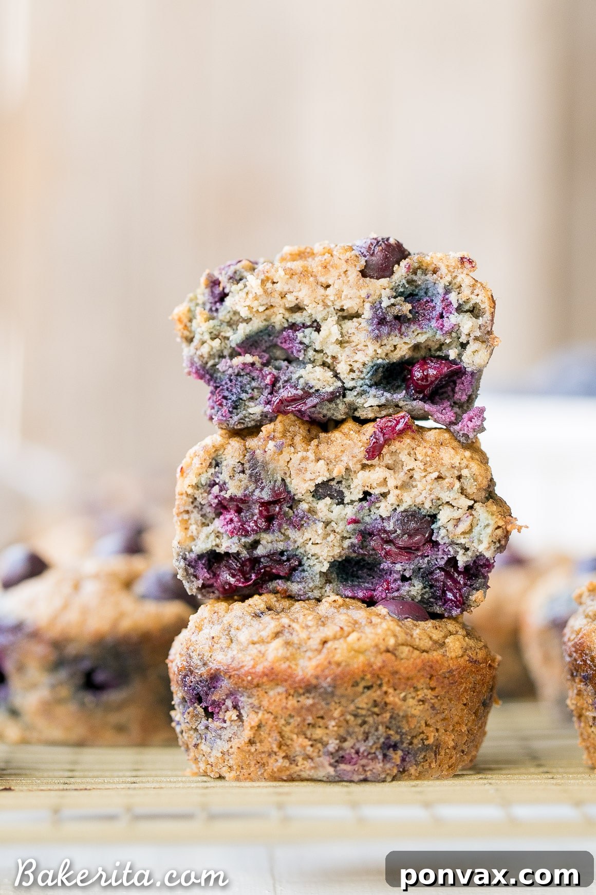 Gluten-Free Banana Blueberry Bliss 4 Freshly baked Gluten-Free Banana Blueberry Muffins cooling on a wire rack, showcasing their golden-brown tops.