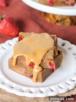 Fresh strawberries and strawberry jelly are swirled into soft peanut butter blondies to create these Peanut Butter & Jelly Bars that taste just like your favorite childhood sandwich! They're super easy and come together in one-bowl.