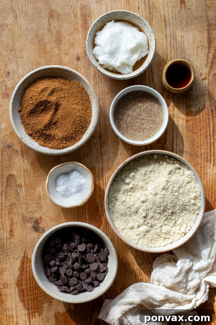 Irresistible Paleo Chocolate Chip Cookies Vegan Friendly 5 Various ingredients for paleo chocolate chip cookies laid out on a wooden board.