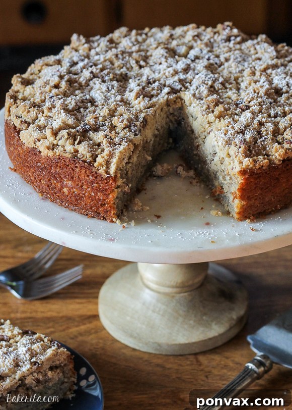 Plant-Based Banana Streusel Cake 2 A stunning Dairy-Free Banana Crumb Cake with a golden pecan crumb topping, sliced and ready to serve. Perfect for breakfast, brunch, or dessert, showcasing its moist texture and rich banana flavor.