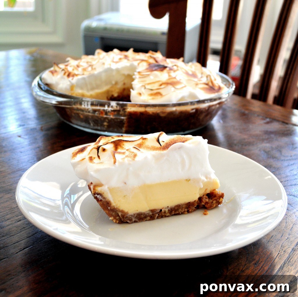 Key Lime Meringue Pie Lush Key Lime Meringue Pie with golden-brown peaks, resting on a white platter, inviting a taste of tropical delight.