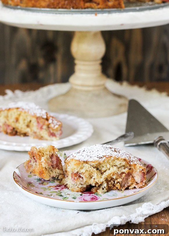 A close-up detail shot of a perfectly cut slice of Caramel Rhubarb Cake, highlighting the moist interior, the soft, fluffy texture of the cake, and the distinct, tender pieces of rhubarb and streaks of caramel generously distributed throughout. This image perfectly captures the cake's deliciousness.