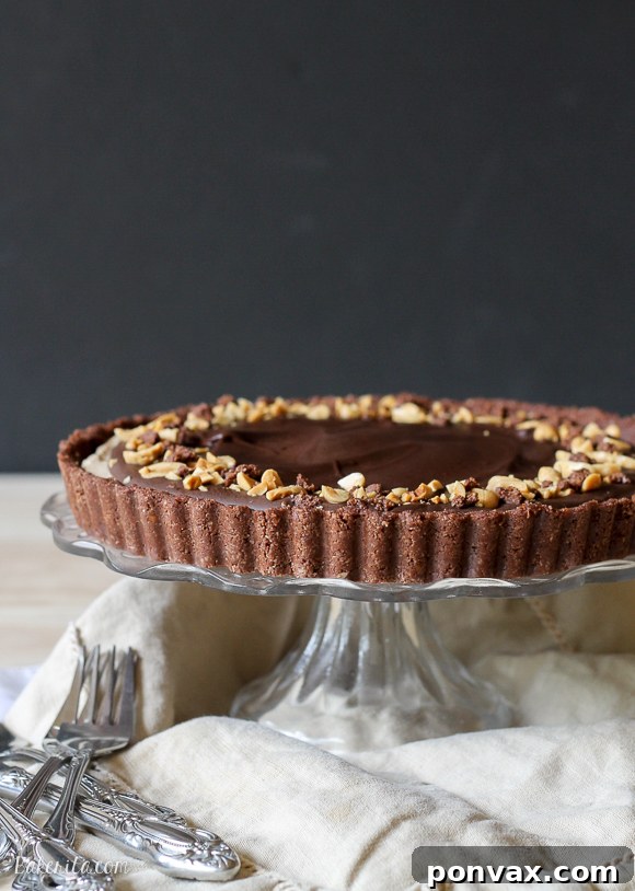 This No Bake Chocolate Peanut Butter Tart has a rich peanut butter filling topped with chocolate ganache for a decadent treat you won't believe is gluten free, refined sugar free, and vegan!