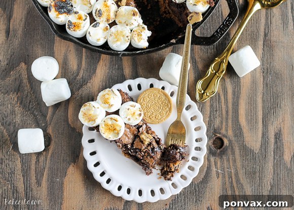 Decadent S'mores Oreo Skillet Brownie 3 A warm S'mores Oreo Skillet Brownie served in a cast iron skillet, garnished with more S'mores Oreos and a dusting of cocoa powder.