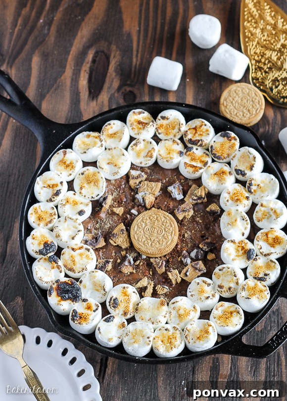 Decadent S'mores Oreo Skillet Brownie 5 A close-up of a S'mores Oreo Skillet Brownie slice, revealing the thick, fudgy center, crushed Oreo crust, and perfectly browned marshmallow.
