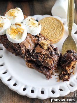 Decadent S'mores Oreo Skillet Brownie 7 S'mores Oreo Skillet Brownie with melted marshmallows and a spoon.